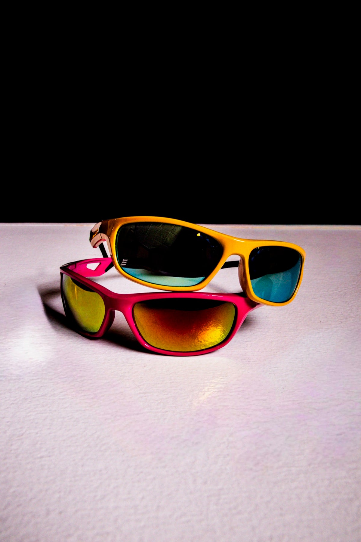 A yellow wrap and a hot pink wrap with mirror lenses